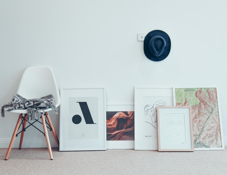 white chair beside five paintings